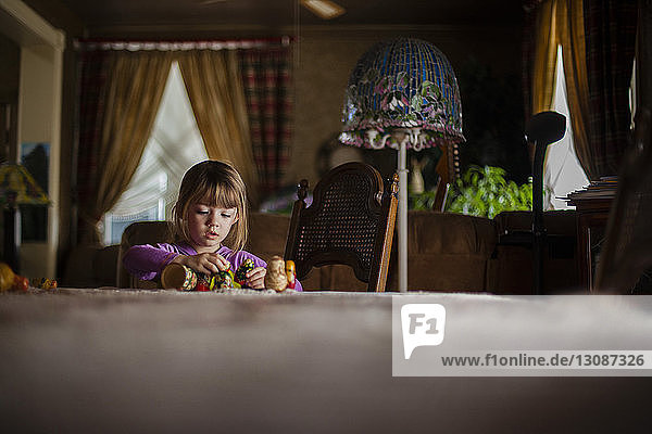 Girl playing with toys at dining table