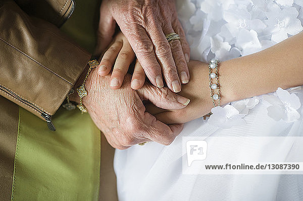 Mitschnitt einer Großmutter  die während der Kommunion die Hände ihrer Enkelin hält
