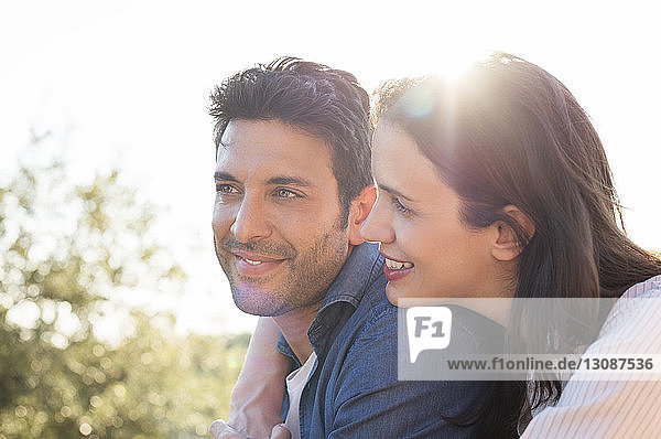 Seitenansicht eines lächelnden Paares gegen den Himmel an einem sonnigen Tag