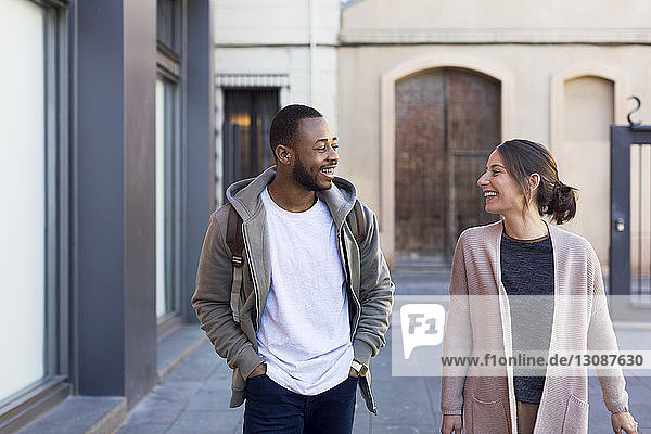 Glückliches Paar kommuniziert beim Spaziergang auf der Straße in der Stadt