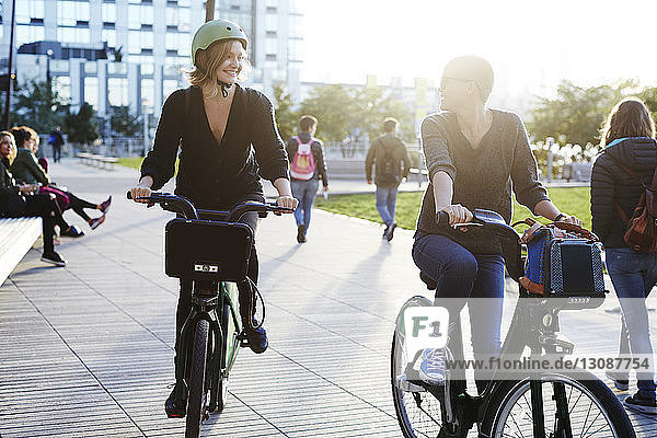 Lächelnde Freunde beim Fahrradfahren auf der Stadtstraße