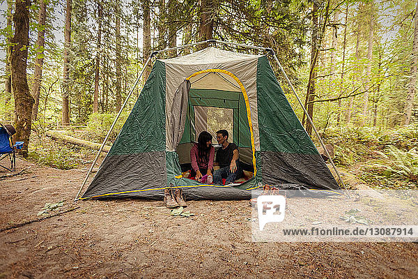Ehepaar sitzt im Zelt auf dem Feld