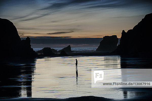 Mid distance view of silhouette person standing at Bandon Beach