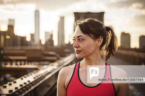 Nahaufnahme einer lächelnden Frau  die auf der Brooklyn Bridge steht