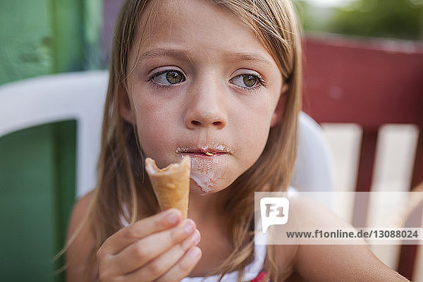 Girl looking away while eating ice cream
