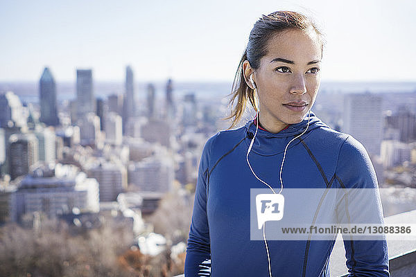 Woman listening to music with cityscape in background