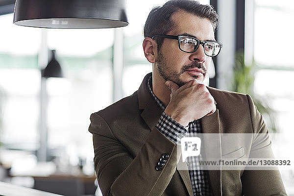 Thoughtful businessman looking away in restaurant