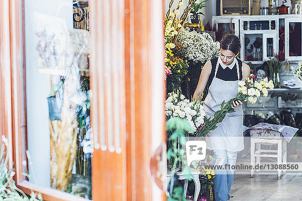 Eigentümer arrangiert Blumenstrauß im Geschäft