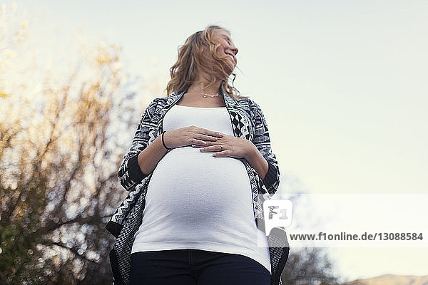 Niedrigwinkelansicht einer schwangeren Frau gegen klaren Himmel