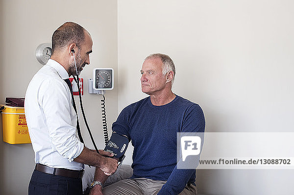 Arzt kontrolliert den Blutdruck des Patienten im medizinischen Untersuchungsraum