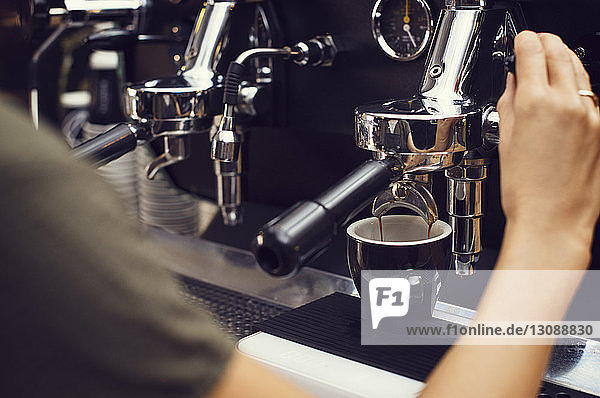 Ausgeschnittenes Bild eines Barista der im Café Kaffee macht