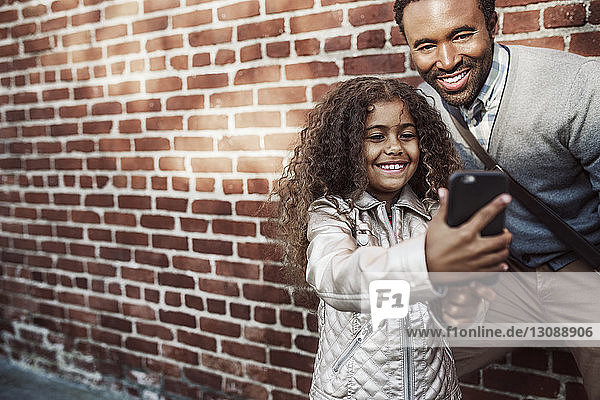Glückliche Tochter nimmt Selfie mit dem Vater per Mobiltelefon