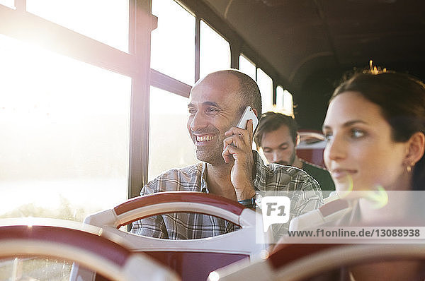 Mann spricht während der Fahrt im Reisebus per Handy