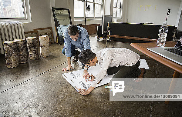 Geschäftsleute schreiben im kreativen Büro an weißer Tafel