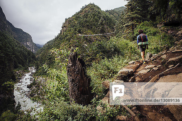 Rückansicht eines Wanderers mit Rucksack beim Bergwandern im Sagarmatha-Nationalpark