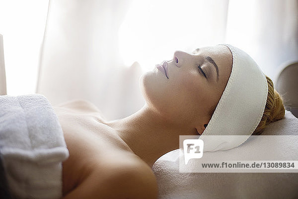 Relaxed woman lying on massage table in spa