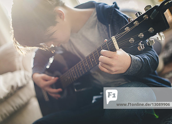 Boy playing guitar at home