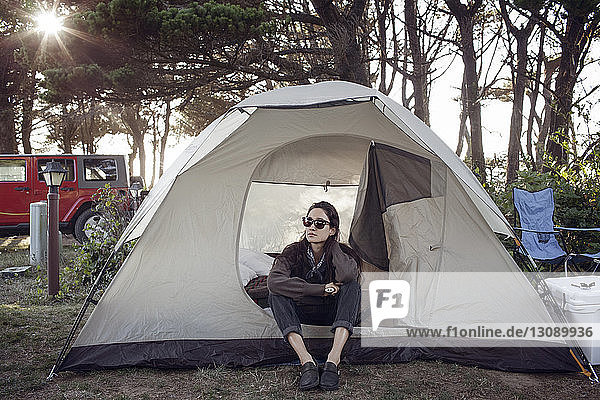 Frau mit Sonnenbrille entspannt sich im Zelt