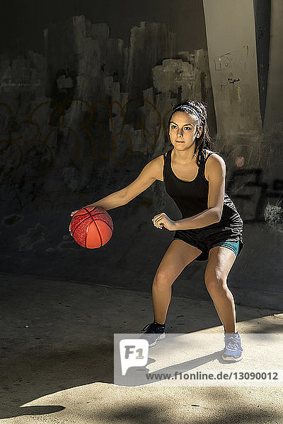 Porträt eines selbstbewussten Sportlers  der Basketball gegen die Wand spielt