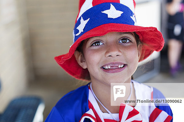 Porträt eines süßen Mädchens mit Hut mit amerikanischer Flagge im Freien