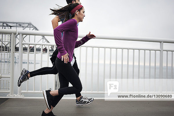 Side view of determined athletes running on Bay Bridge