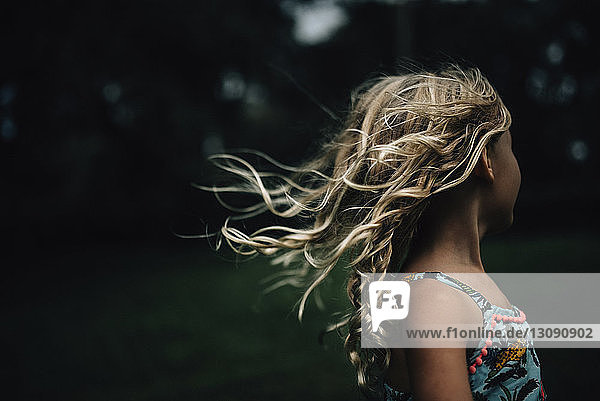 Side view of girl with tousled hair at park