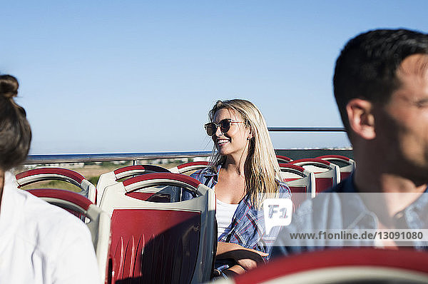 Touristen reisen im Doppeldeckerbus bei strahlend blauem Himmel