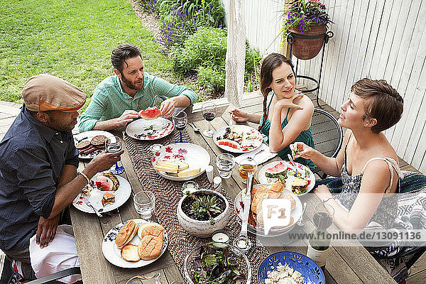High angle view of friends at table in yard