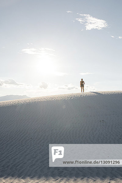Rückansicht der am White Sands National Monument stehenden Frau gegen den Himmel
