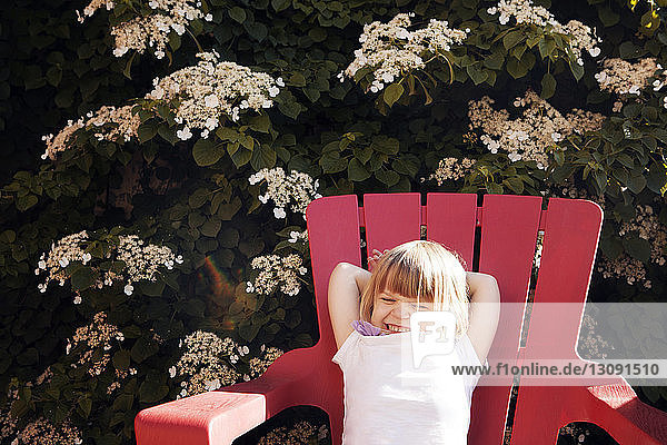 Süßes Mädchen entspannt sich auf einem Liegestuhl im Hof