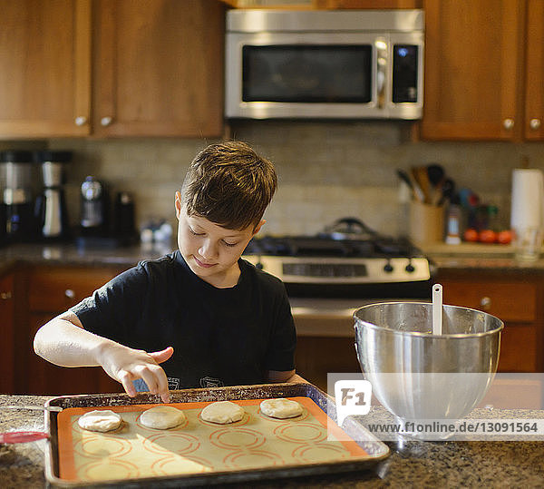 Junge bereitet Kekse zu  während er zu Hause in der Küche steht