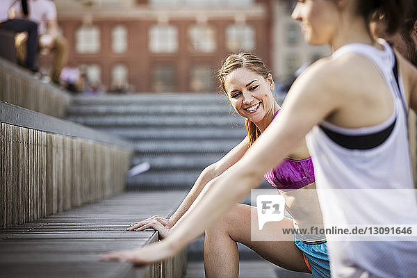 Glückliche Freunde trainieren auf einer Treppe im Park
