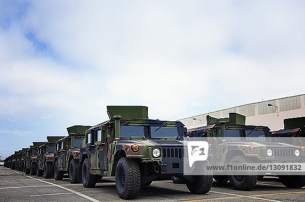 Militärfahrzeuge bei der Industrie vor bewölktem Himmel geparkt