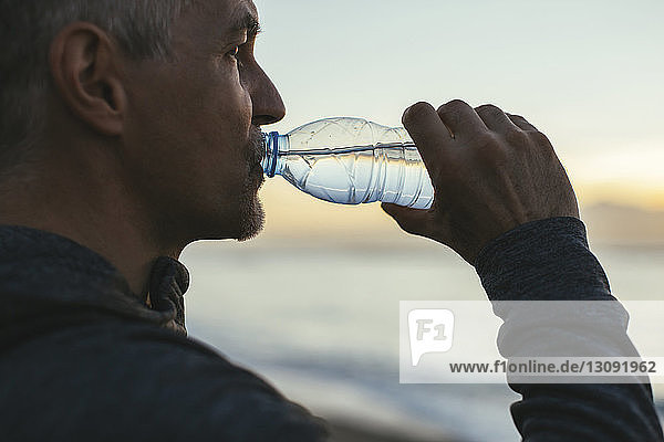 Nahaufnahme eines Mannes Trinkwasser am Strand
