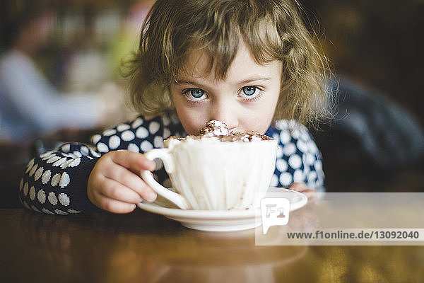 Porträt eines Mädchens mit Eiskaffee-Schokoladeneis im Café