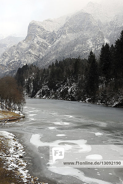 Landschaftliche Ansicht eines zugefrorenen Sees vor den Bergen im Winter