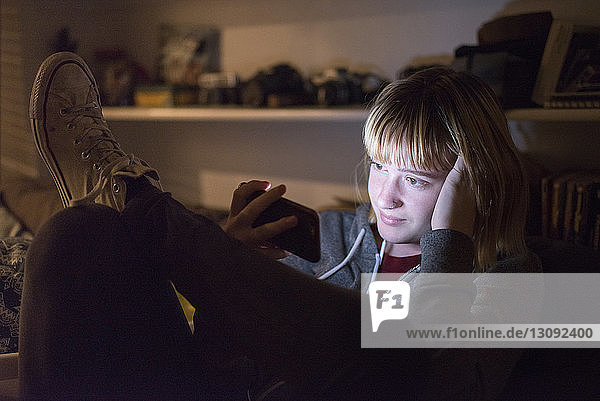 Teenagerin benutzt zu Hause ein Smartphone