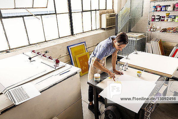 Mann malt während der Arbeit in der Werkstatt auf Papier