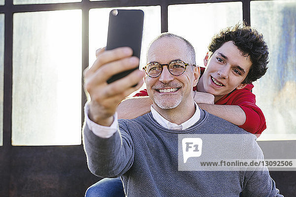 Happy father taking selfie with son