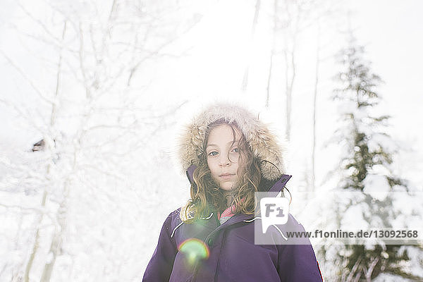 Niedrigwinkel-Porträt eines Mädchens in warmer Kleidung  das im Winter gegen den Himmel steht