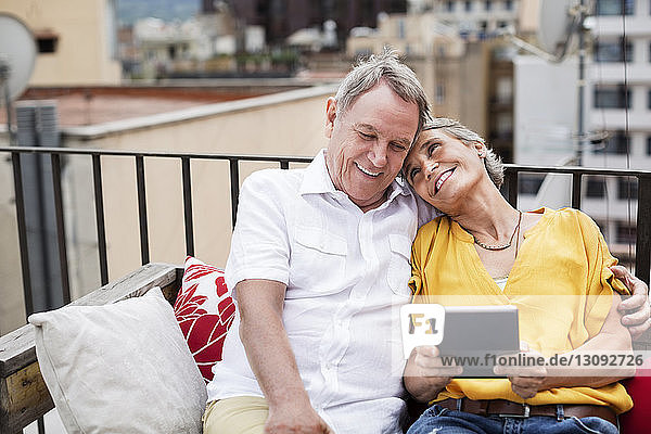 Loving senior couple sitting on bench at terrace