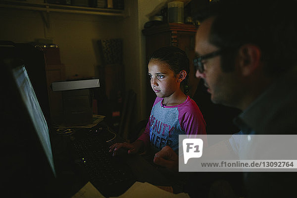 Schwere Tochter benutzt Desktop-Computer vom Vater zu Hause