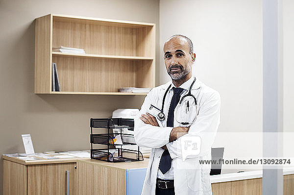Porträt eines Arztes mit verschränkten Armen im Krankenhauszimmer stehend