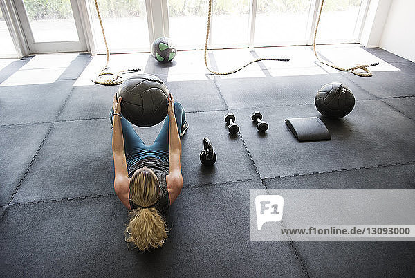 High angle view of athlete exercising with medicine ball in crossfit gym