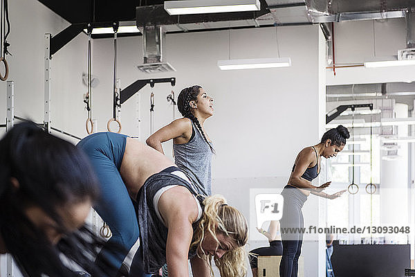 Female athletes doing burpee exercise in crossfit gym