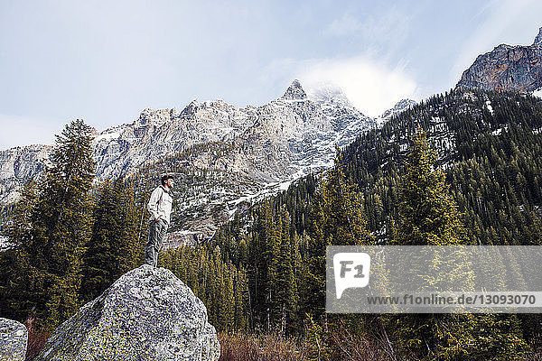 Tiefwinkelaufnahme eines auf einem Felsen stehenden Mannes im Grand-Teton-Nationalpark
