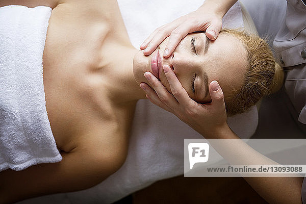 Overhead view of woman receiving massage from female therapist in spa