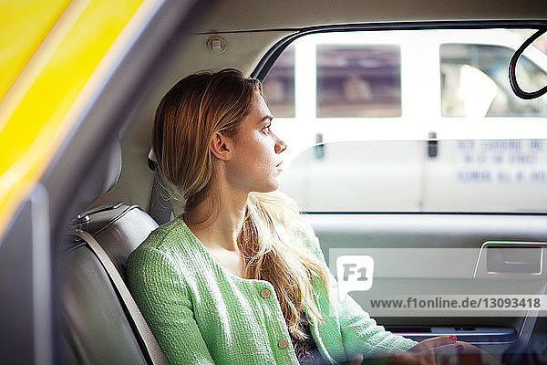 Porträt einer Frau  die in der Stadt im Taxi sitzt