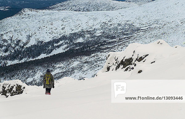 Hochwinkelaufnahme eines Wanderers auf einem schneebedeckten Berg