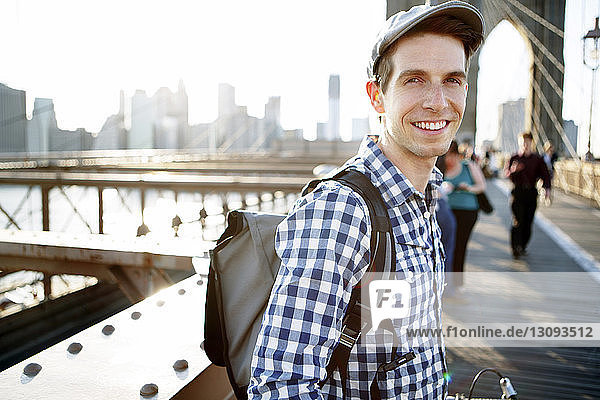 Porträt eines lächelnden Mannes auf der Brooklyn Bridge